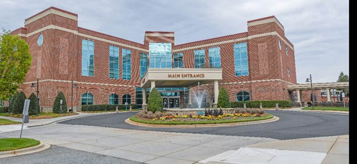 A building with a fountain in front of it Description automatically generated