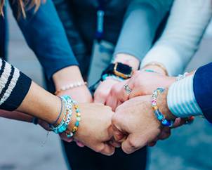 A group of people holding hands AI-generated content may be incorrect.